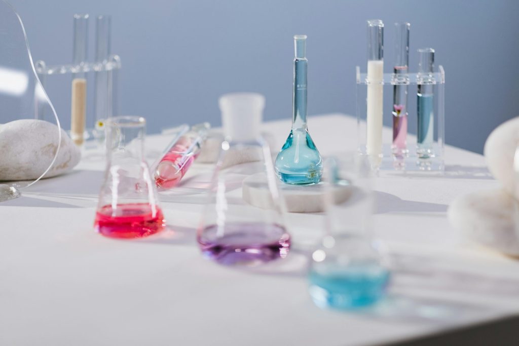 Lebendige Flüssigkeiten in Glasgefäßen auf einem Labortisch in einer modernen wissenschaftlichen Umgebung.