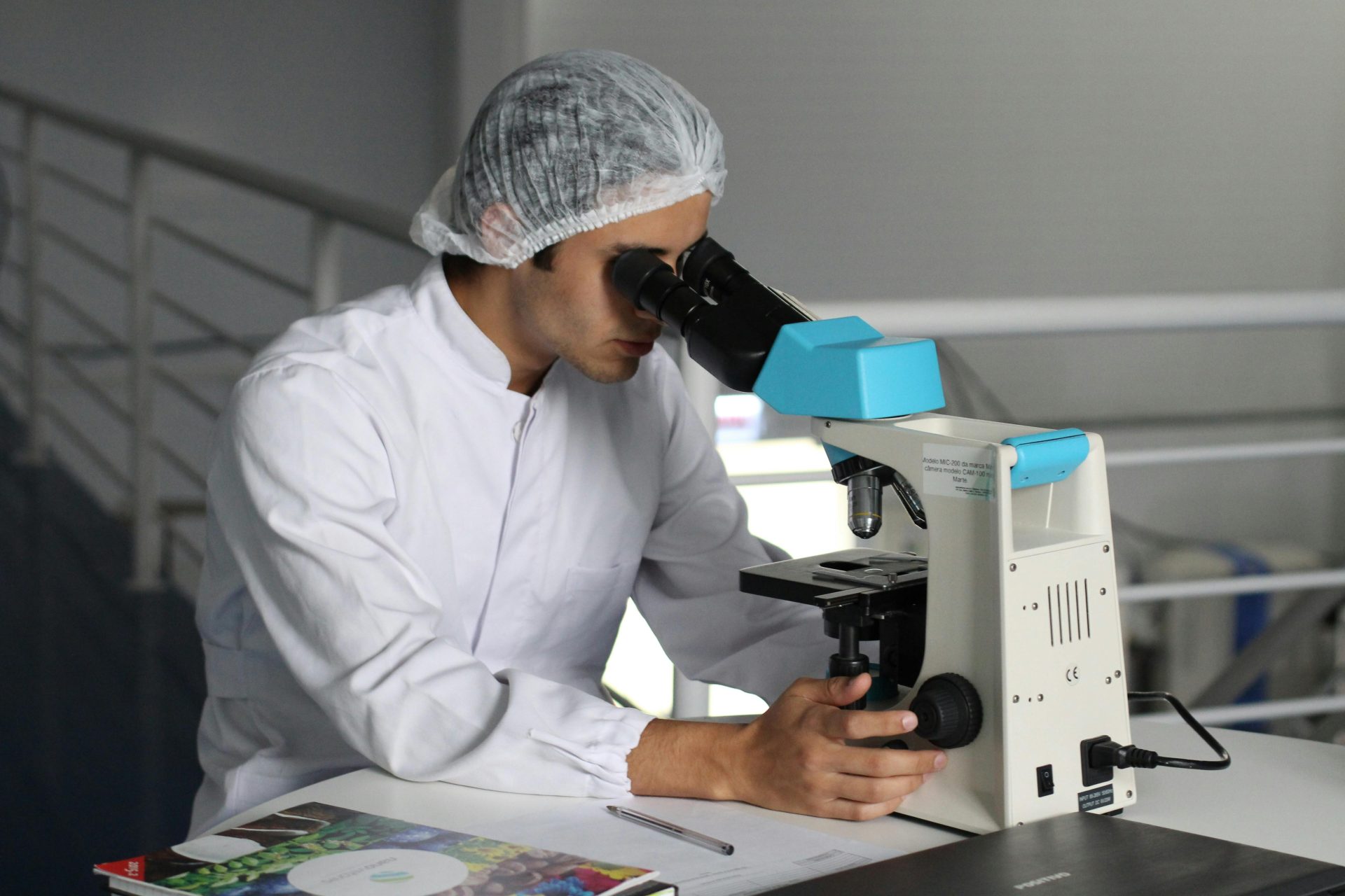 Wissenschaftler im Laborkittel forschen unter einem Mikroskop und konzentrieren sich dabei auf Verbesserungen im Gesundheitswesen.