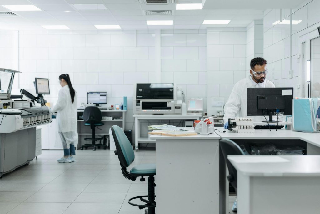 Researchers in protective gear conduct experiments in a high-tech lab environment.
