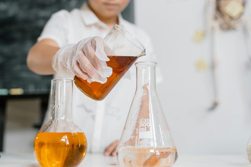 Wissenschaftler führen ein Experiment durch, indem sie Flüssigkeit in einen Kolben gießen.